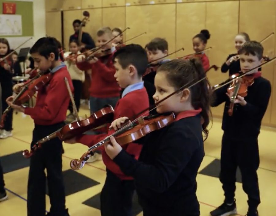 Children playing violins in the PRESTO music programme